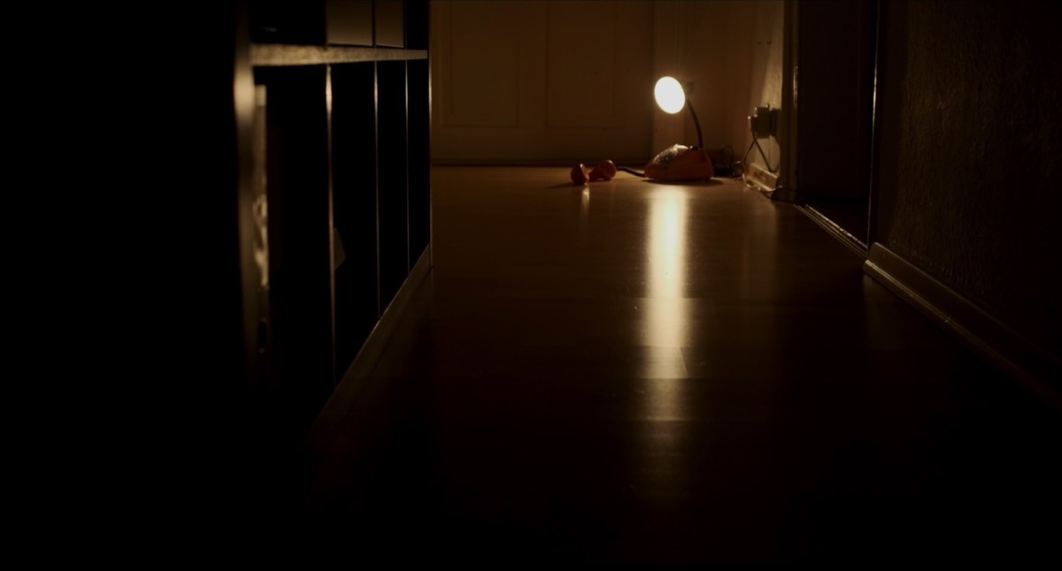 A door is open just a crack, letting light into the room