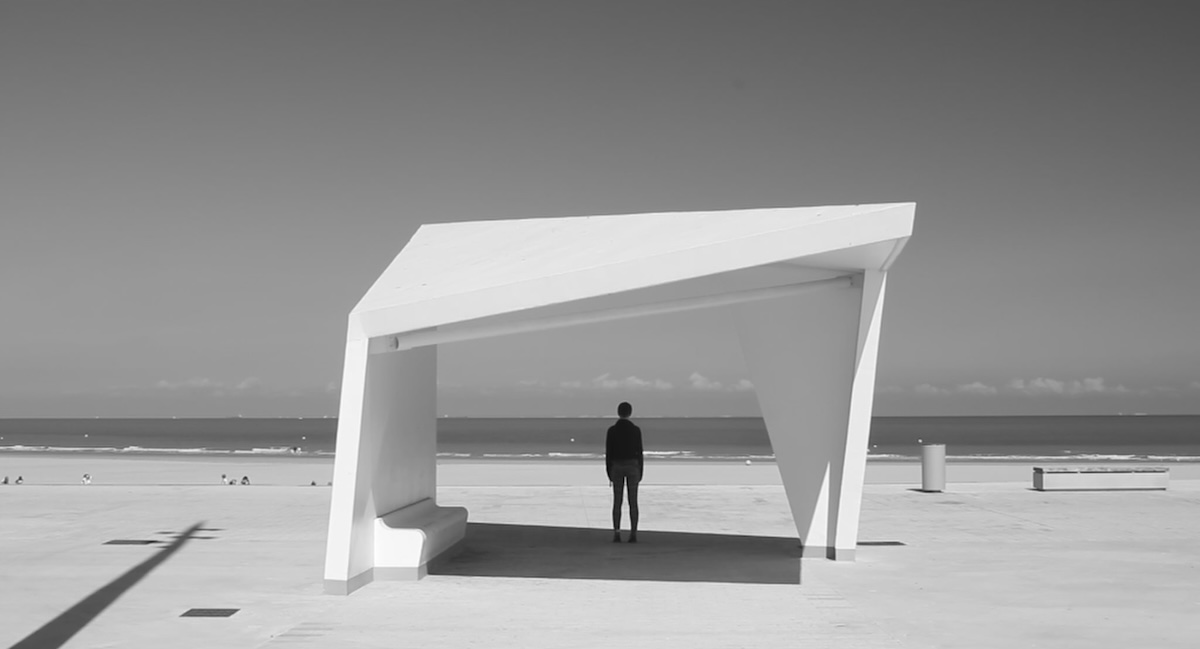 a person stands at the beach of calais in france and looks at the sea